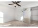 Bright bedroom with mirrored closet doors and ceiling fan at 11640 W Duran Ave, Youngtown, AZ 85363