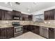 Kitchen boasts dark cabinetry, granite counters, and stainless steel appliances at 11640 W Duran Ave, Youngtown, AZ 85363