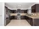 Modern kitchen with dark wood cabinets and granite countertops at 11640 W Duran Ave, Youngtown, AZ 85363