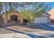 Tan house with a two car garage and mature landscaping at 1227 W Delmonte Dr, Casa Grande, AZ 85122