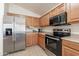 Kitchen with stainless steel appliances and wood cabinets at 1227 W Delmonte Dr, Casa Grande, AZ 85122