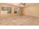 Living room with ceiling fan, neutral walls and carpet, and backyard access at 12677 N 140Th Dr, Surprise, AZ 85379