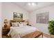 Bright bedroom with a wooden bed frame, bedside lamps, and a window with blinds at 14033 W Two Guns Trl, Surprise, AZ 85374