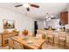 Charming dining area with wooden table set for four, flowing into the kitchen with barstool seating at 14033 W Two Guns Trl, Surprise, AZ 85374