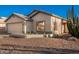 Single story house with a beige exterior, attached garage and desert landscaping at 14033 W Two Guns Trl, Surprise, AZ 85374