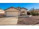 Single-story house with a beige exterior, attached garage, and desert landscaping at 14033 W Two Guns Trl, Surprise, AZ 85374