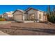 House with a two-car garage and gravel landscaping in the front yard at 14033 W Two Guns Trl, Surprise, AZ 85374