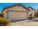 Front view of a house with a beige exterior and a two-car garage at 14033 W Two Guns Trl, Surprise, AZ 85374