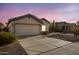 Inviting single-story home featuring a spacious driveway, a two-car garage and mature desert landscaping at 14033 W Two Guns Trl, Surprise, AZ 85374