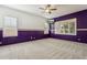 Spacious bedroom with purple walls, neutral carpet, and ceiling fan at 1440 S Central Dr, Chandler, AZ 85286