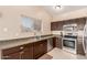 Kitchen with stainless steel appliances and dark wood cabinets at 14529 N 87Th Dr, Peoria, AZ 85381