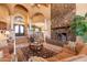 Elegant living room with a stone fireplace and arched windows at 15225 N Bluejay Pl, Fountain Hills, AZ 85268