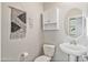 Small bathroom with pedestal sink and white toilet at 1693 E Dogwood Ln, Gilbert, AZ 85295