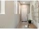Neutral entryway featuring a light beige wall and a wooden bench topped with a potted plant at 1693 E Dogwood Ln, Gilbert, AZ 85295