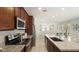 Gourmet kitchen with stainless steel appliances, granite counters, dark cabinets, and open layout at 1693 E Dogwood Ln, Gilbert, AZ 85295