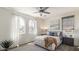 Sunlit main bedroom featuring large windows with sheer curtains, neutral decor, and a ceiling fan at 1693 E Dogwood Ln, Gilbert, AZ 85295