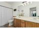 Bathroom with a wood vanity, double sinks, a toilet, and a shower behind a striped curtain at 1885 W Dion Dr, Phoenix, AZ 85086