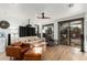 Bright living room featuring light wood floors, tan sofa with pillows, and sliding doors to the backyard at 1885 W Dion Dr, Phoenix, AZ 85086