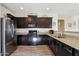 Modern kitchen featuring dark wood cabinets, granite countertops, and stainless steel appliances at 19371 N Nocera Rd, Maricopa, AZ 85138