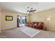 Living room with leather sofa, ceiling fan, and access to backyard at 19371 N Nocera Rd, Maricopa, AZ 85138