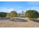 Gravel backyard with mature citrus trees and a view of the home's exterior at 19619 N Signal Butte Cir, Sun City, AZ 85373