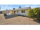 Rear view of a single-story house with a covered patio and gravel yard at 19619 N Signal Butte Cir, Sun City, AZ 85373