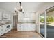 Modern kitchen with white cabinets and sliding glass door at 19619 N Signal Butte Cir, Sun City, AZ 85373