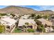 Aerial view of house, backyard, and putting green, near lake and mountains at 21964 N 59Th Ln, Glendale, AZ 85310