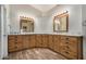 Bathroom with double sinks, wood cabinets, and granite countertops at 21964 N 59Th Ln, Glendale, AZ 85310