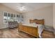 Bright bedroom with wood flooring, ceiling fan, and sitting area at 21964 N 59Th Ln, Glendale, AZ 85310