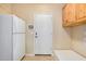 Laundry room with white refrigerator, built-in cabinets and bench at 21964 N 59Th Ln, Glendale, AZ 85310