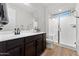 Bathroom with dark vanity, large mirror, and a walk-in shower at 23059 E Pummelos Rd, Queen Creek, AZ 85142