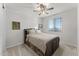 Bedroom with wooden bed frame, ceiling fan, and neutral color scheme at 23059 E Pummelos Rd, Queen Creek, AZ 85142