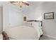 Bright bedroom with wooden bed frame, ceiling fan, and neutral walls at 23059 E Pummelos Rd, Queen Creek, AZ 85142