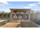 Wooden gazebo with seating area in a grassy backyard at 23059 E Pummelos Rd, Queen Creek, AZ 85142