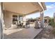 Covered patio with table and chairs, adjacent to backyard at 23059 E Pummelos Rd, Queen Creek, AZ 85142