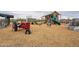 Playground with a red tractor and playhouse at 23059 E Pummelos Rd, Queen Creek, AZ 85142