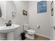 Small powder room with pedestal sink, toilet, and wood-look tile floor at 23059 E Pummelos Rd, Queen Creek, AZ 85142