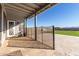 Covered patio with tile flooring, access door, and view of grassy backyard at 24421 W Morning Vista Ln, Wittmann, AZ 85361