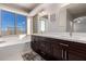 Elegant bathroom with double sinks, soaking tub, and modern vanity at 24421 W Morning Vista Ln, Wittmann, AZ 85361