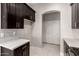 Modern kitchen with dark cabinetry, quartz countertops, and stainless steel appliances at 24421 W Morning Vista Ln, Wittmann, AZ 85361