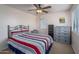 Bedroom with striped bedding and a dresser at 26133 W Yukon Dr, Buckeye, AZ 85396