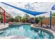 Inviting kidney-shaped pool with a built-in spa and shade sail at 26133 W Yukon Dr, Buckeye, AZ 85396