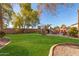 Large backyard with a grassy lawn, patio, and built-in grill at 4221 E Carriage Way, Gilbert, AZ 85297