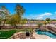 Backyard features a pool, outdoor kitchen, and string lights at 4221 E Carriage Way, Gilbert, AZ 85297