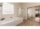 Spa-like bathroom with a soaking tub, glass shower, and updated fixtures at 4221 E Carriage Way, Gilbert, AZ 85297