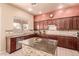 Spacious kitchen featuring granite countertops and dark wood cabinetry at 4221 E Carriage Way, Gilbert, AZ 85297