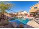 Inviting pool with rock waterfall feature and surrounding landscaping at 4221 E Carriage Way, Gilbert, AZ 85297