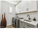 Laundry room with gray cabinets, quartz countertops, and a utility sink at 4910 S Huachuca Pl, Chandler, AZ 85249