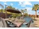 Poolside dining table with seating for six under an umbrella at 4910 S Huachuca Pl, Chandler, AZ 85249